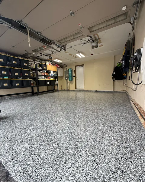 After: the same garage with a finished grey flake epoxy floor