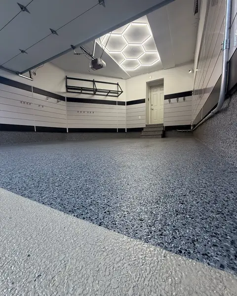 Flake epoxy garage floor with hexagon LED ceiling lights and slatwall